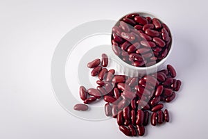 Red beans in a white ceramic cup on a white background