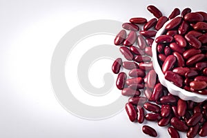 Red beans in a white ceramic cup on a white background