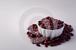 Red beans in a white ceramic cup on a white background