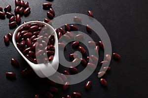 Red beans in a white cup on a black background. copys pace. top view. Vegetarian food