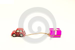 Red beetle car are dragging pink gift box white