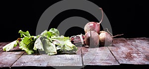 Red Beetroot with herbage green leaves on rustic background. Org