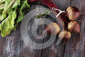 Red Beetroot with herbage green leaves on rustic background. Org