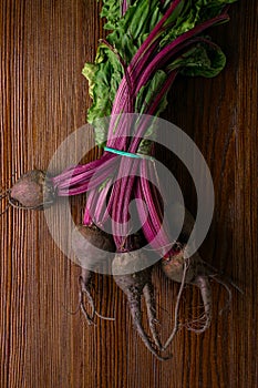 Red Beetroot with herbage green leaves on rustic background. Organic Beetroot.