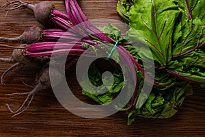Red Beetroot with herbage green leaves on rustic background. Organic Beetroot. Detox