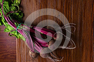 Red Beetroot with herbage green leaves on rustic background. Organic Beetroot. Detox. Selective focus