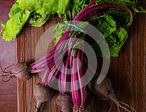 Red Beetroot with herbage green leaves on rustic background. Organic Beetroot. Detox. Selective focus