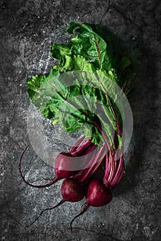 Red Beetroot with herbage green leaves on stone background