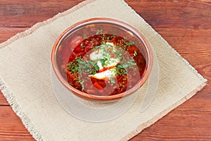 Red beetroot Ukrainian borscht in ceramic bowl on rustic table