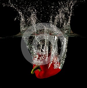 Red bell pepper dropped and slashing on water