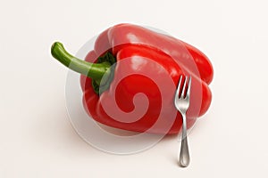 Red bell pepper and fork on a light background. Space for text.
