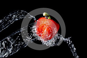 Red bell pepper gets hit by a water stream