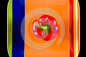 Red Bell Pepper Sitting on a Colorful Dish