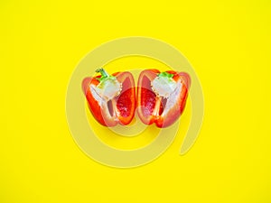 Red bell pepper sliced with seeds isolated in yellow background
