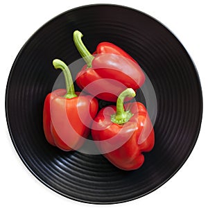 Red Bell Peppers on Black Plate Isolated on White