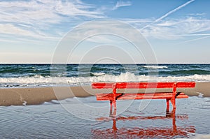 Red bench on the beach