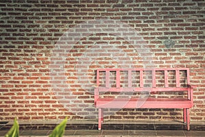 The red bench and the brick wall are the background.