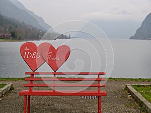 Red bench with heart near the lake Idro, Brescia, Italy