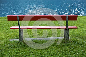 Red bench at lake shore