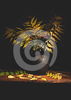 Red berries and berry tree branches in a black vase on a wooden table with dark background