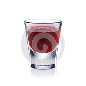 Red berries liqueur is the shot glass isolated on white.