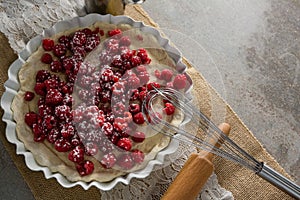 Red berries on tart with whisker and rolling pin