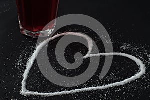 Red berries tea in glass, spilled sugar