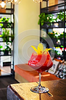 Red, berry, alcoholic cocktail in a glass goblet on a short leg