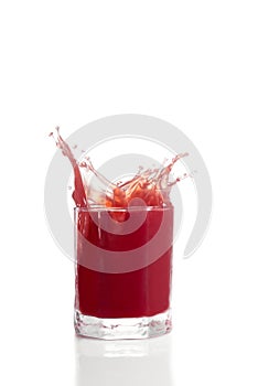 Red berry juice spilling over glass