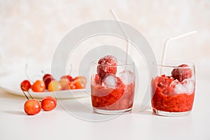 Red berry lemonade in glass jar on a wooden background with lemon slices, honey and ice. Top view