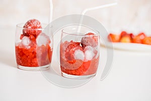 Red berry lemonade in glass jar on a wooden background with lemon slices, honey and ice. Top view