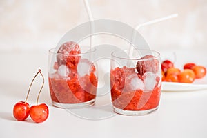 Red berry lemonade in glass jar on a wooden background with lemon slices, honey and ice. Top view