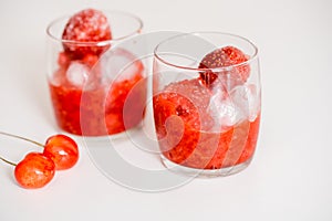 Red berry lemonade in glass jar on a wooden background with lemon slices, honey and ice. Top view
