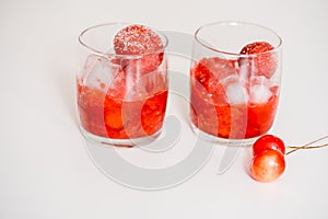 Red berry lemonade in glass jar on a wooden background with lemon slices, honey and ice. Top view