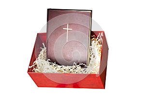 Red bibile in the gift box with paper filling on white background. photo