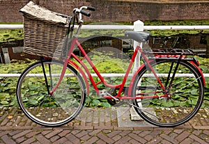 Red Bicycle with Basket Parked Beside Canal in Holland