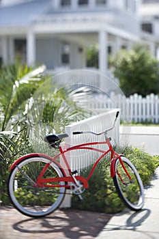Red bicycle in front of house.