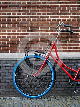 Red Bicycle Leaning Against Brick Wall