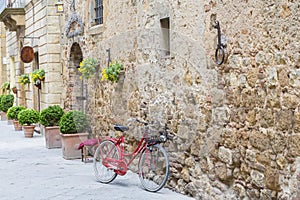 Red bicycle leaning against a wall