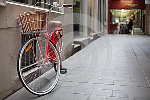 A red bicycle parked in a laneway photo