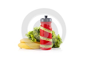 A red bicycle water bottle wrapped with a plastic yellow measuring tape with green lettuce in the white background