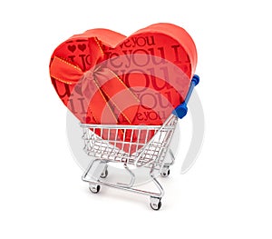 Red big heart-shaped gift with bow for Valentine`s Day in shopping cart