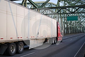 Red big rig semi truck transporting commercial cargo in dry van