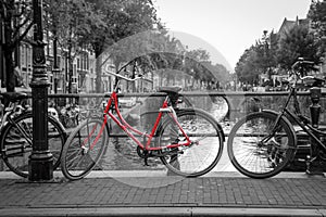 A red bike on the bridge over the channel in Amsterdam