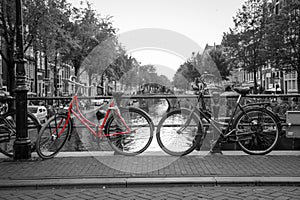 A red bike on the bridge over the channel in Amsterdam