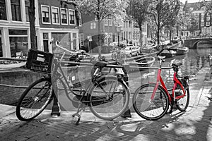 A red bike on the bridge over the channel in Amsterdam