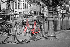 A red bike on the bridge over the channel in Amsterdam