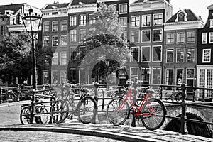 A red bike on the bridge over the channel in Amsterdam