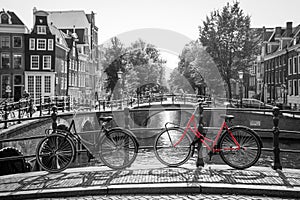 A red bike on the bridge over the channel in Amsterdam