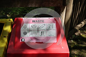 Red waste bin with sorting sign